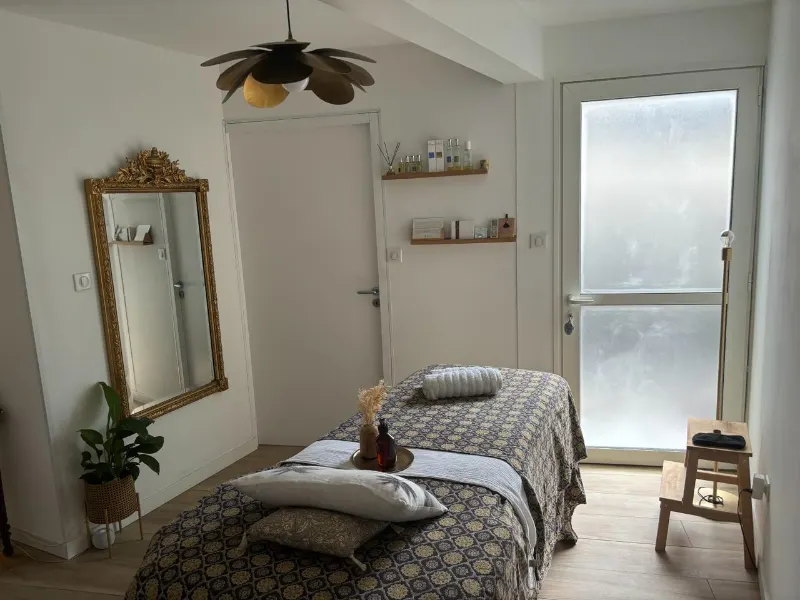 La cabine de soins, table de massage et grand miroir doré